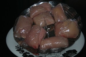 Las pechugas rellenas y envueltas en film transparente listas para entrar en la cubeta, en el cestillo para cocer al vapor